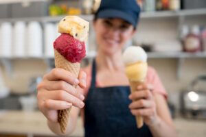 An ice cream vendor holding two cones
